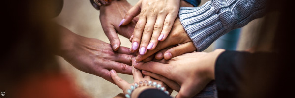 Hände, die in der Mitte aufeinander liegen
